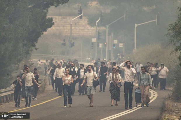 آتش در لانه عنکبوت؛ تصاویری از فرار بی سابقه صهیونیست ها به دلیل آتش سوزی سهمگین در فلسطین اشغالی 