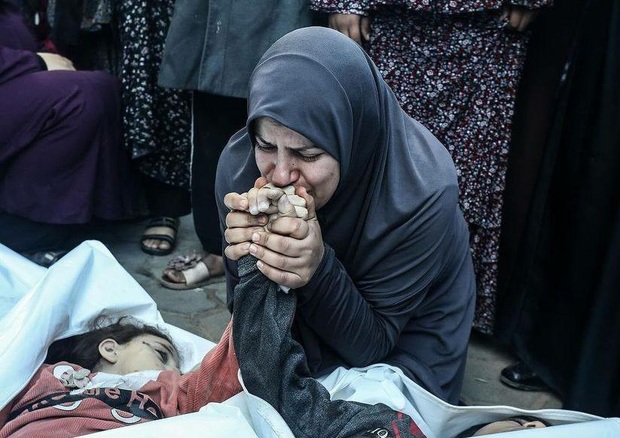 بوسه مادر فلسطینی بر دستان دوقلوهای شهیدش + عکس ها